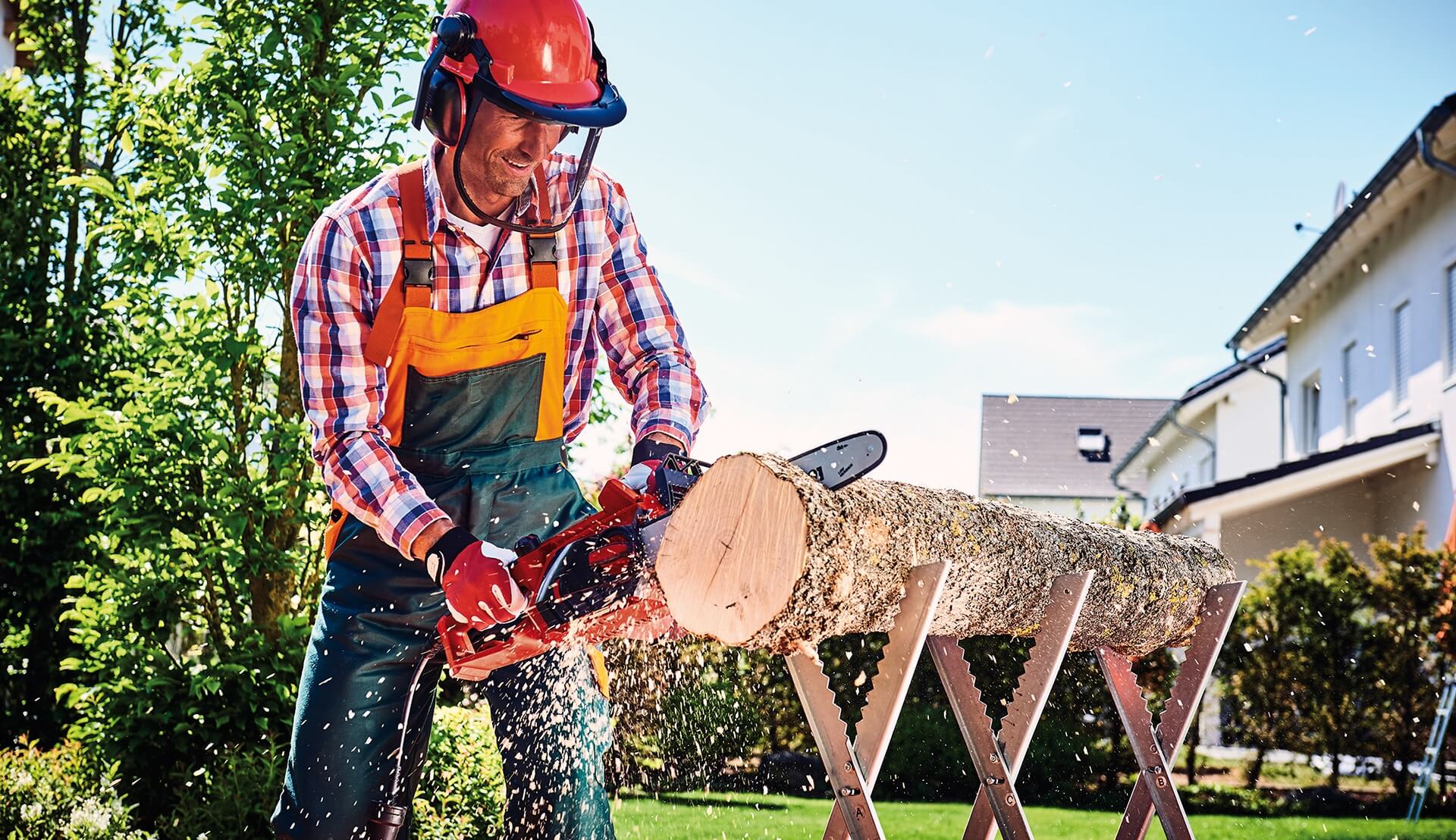 man cuts a tree trunk with the chainsaw